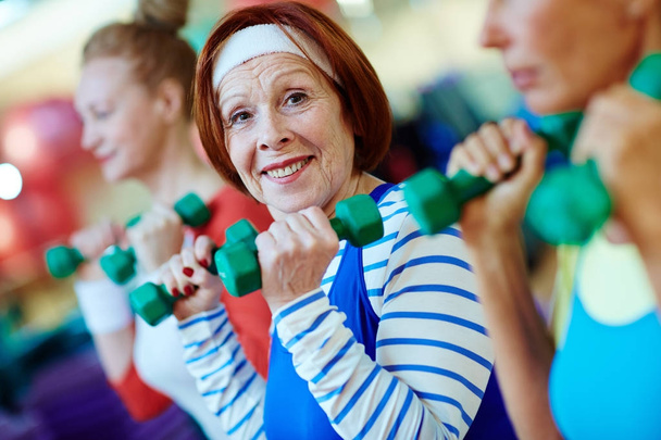 Femme âgée en bonne santé avec haltères pratiquant l'exercice physique
 - Photo, image