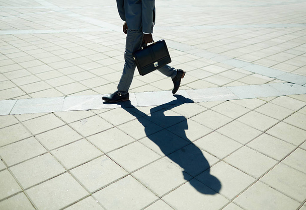 Low sectin of hurrying man on pavement - Foto, afbeelding