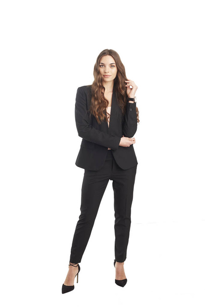 Full length studio shot of a young woman wearing office wear while standing at isolated white background.  - Fotoğraf, Görsel