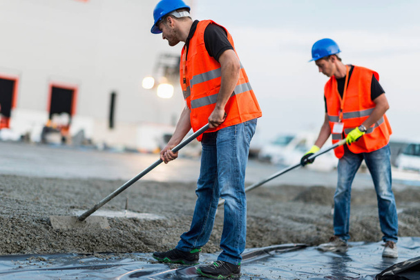 Manual workers leveling concrete - Photo, Image