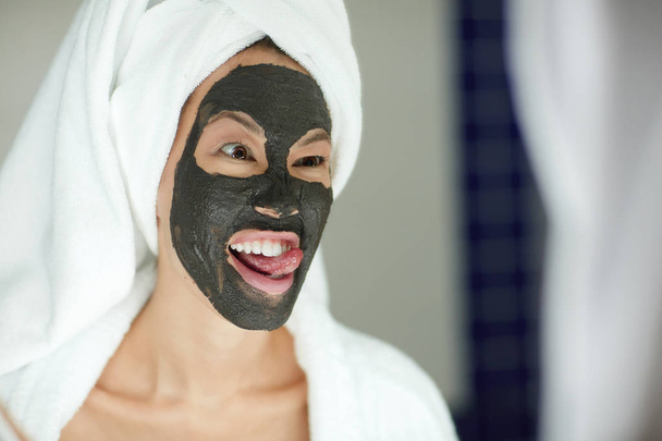 Retrato de bela mulher asiática aplicando máscara facial
  - Foto, Imagem