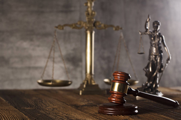Статуя правосудия и молоток судьи на каменном фоне и деревенский деревянный стол
. - Фото, изображение