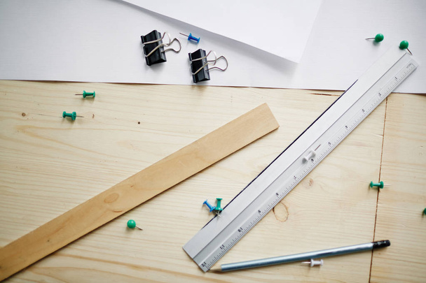 Vista superior de los suministros de medición sobre la mesa: reglas, lápiz y papel dispuestos en el escritorio de ingeniería
 - Foto, imagen