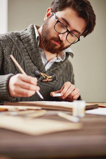 Brodaty malarz w okularach i sweter rysunek w miejscu pracy - Zdjęcie, obraz