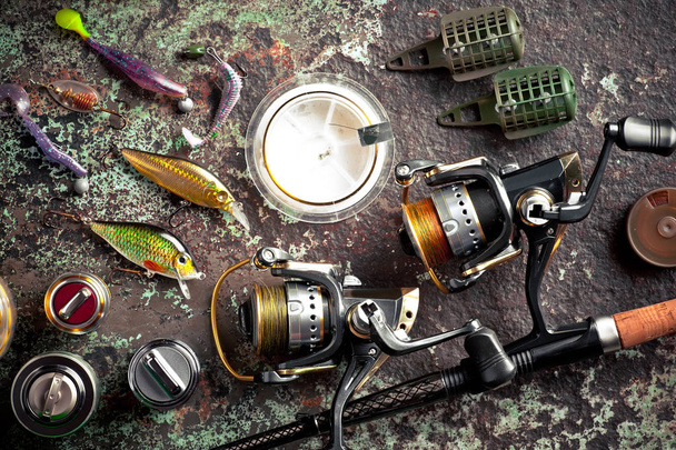 Canne da pesca e filature nella composizione con accessori per la pesca sul vecchio sfondo sul tavolo
 - Foto, immagini