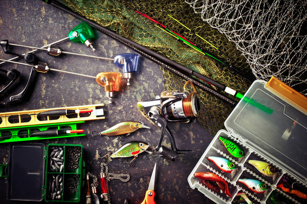 Canne da pesca e filature nella composizione con accessori per la pesca sul vecchio sfondo sul tavolo
 - Foto, immagini