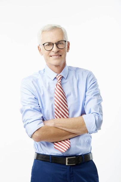 Senior businessman in glasses with arms crossed wearing shirt and tie and smiling, isolated on white - Foto, imagen
