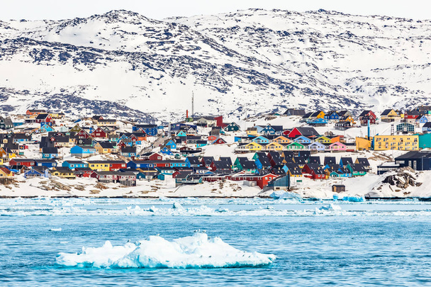 Vista panorámica de la ciudad de nieve ártica con coloridas casas inuit en la roca
 - Foto, imagen