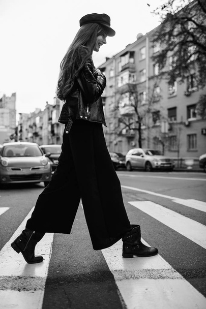 Beautiful girl with sunglasses. A model in a stylish wide-brimmed hat at a pedestrian crossing. Harmoniously similar clothes in gray tones. Street style shooting. Women's fashion. - Foto, Imagem