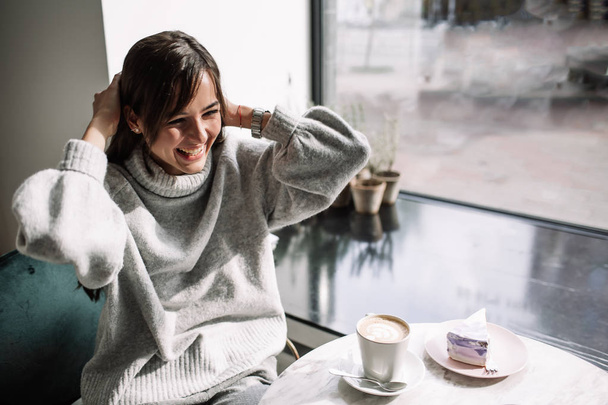 Beautiful girl laughs drinks coffee, tea - Fotografie, Obrázek