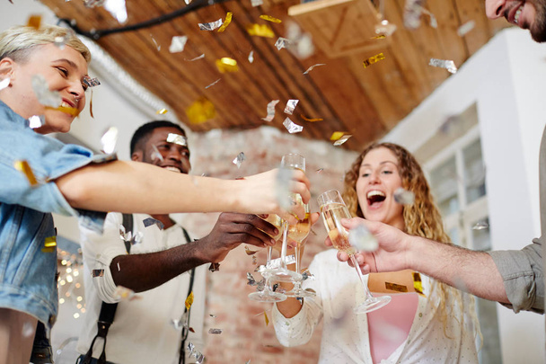 Група схвильованих друзів підбадьорює з флейтами шампанського на вечірці
 - Фото, зображення