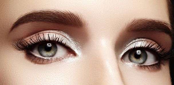 Closeup female eyes with bright make-up, great shapes brows, extreme long eyelashes. Celebrate makeup, luxury eyeshadows - Photo, Image