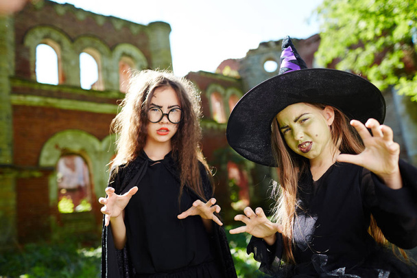 Twee boze heksen tonen beangstigend overhandigen gebaar aan u - Foto, afbeelding