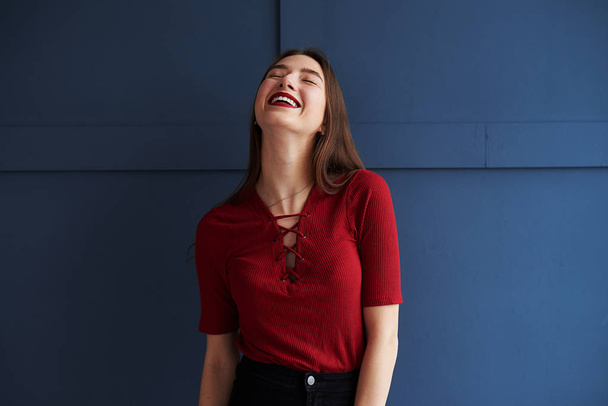 Positive girl with red lips posing against background  - Valokuva, kuva