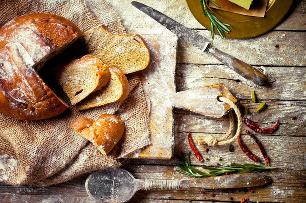 Bread and pastries in a composition with kitchen accessories on an old background - Zdjęcie, obraz