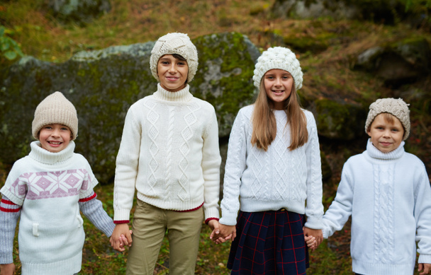 Bambini amichevoli in maglia casualwear tenere per mano
 - Foto, immagini
