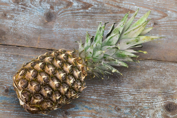 Ripe pineapple on a wooden background top view - 写真・画像
