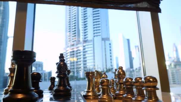 Ajedrez negro y oro de cerca con el paisaje de la ciudad con fondo rascacielos. Formación estratégica de negocios en el juego de ajedrez con fondo de ciudad
 - Metraje, vídeo