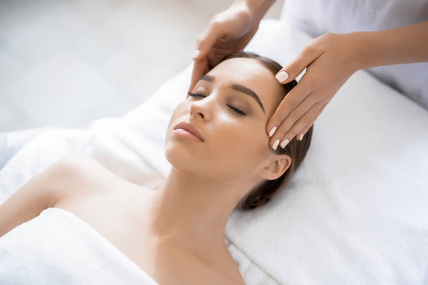 Giovane donna godendo procedura spa con il viso nel lussuoso salone di massaggio
 - Foto, immagini