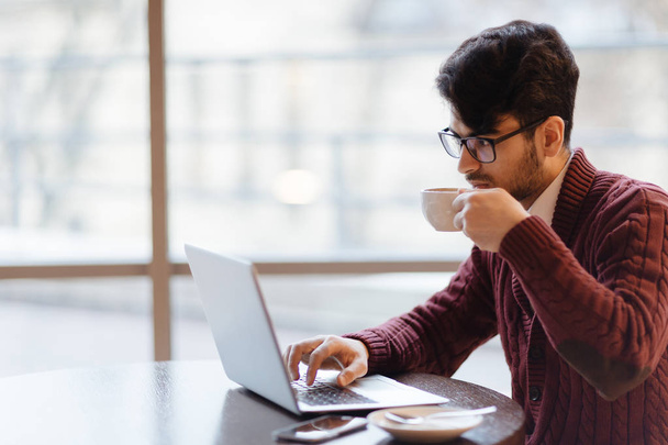 Підприємець читає онлайн дані та п'є каву
 - Фото, зображення
