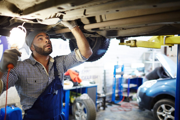 Car service worker repairing one of machines - Photo, Image