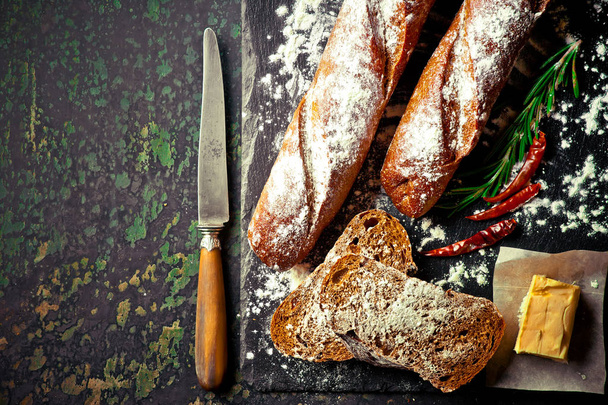 Bread and pastries in a composition with kitchen accessories on an old background - Fotó, kép