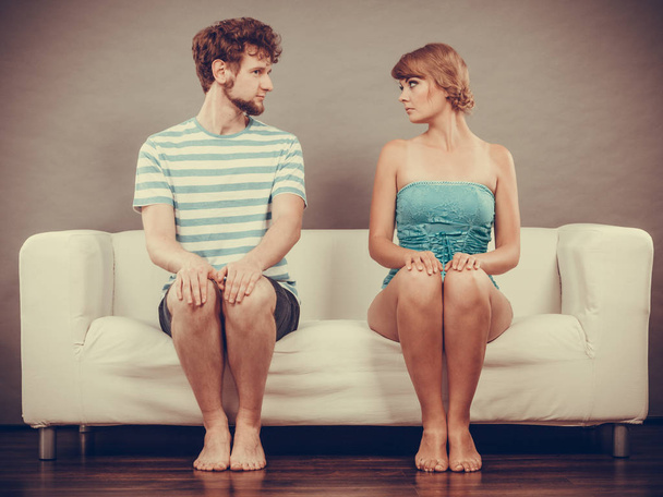 жінка і чоловік сидять на дивані, дивлячись один на одного
. - Фото, зображення