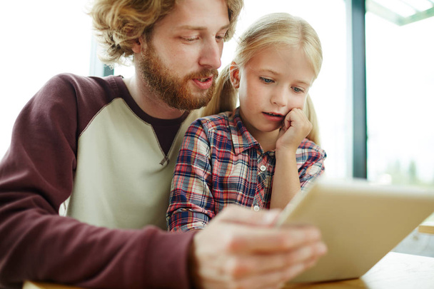 Mann und Tochter blättern im Café Online-Menü auf Tablet durch - Foto, Bild