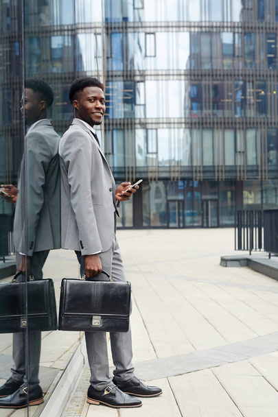 Uomo d'affari moderno con valigetta in ambiente urbano
 - Foto, immagini