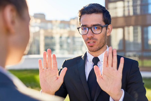 Businessman showing palms gesture during talk to colleague - Photo, Image