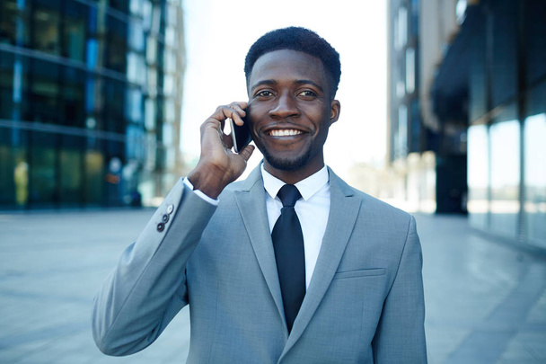 Úspěšným bankéřem s smartphone volání v obchodní čtvrti - Fotografie, Obrázek