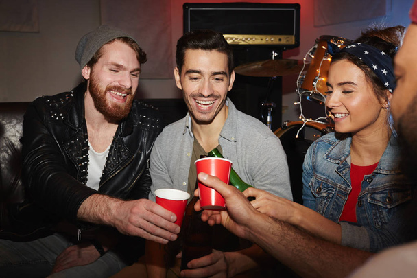 Amigos saindo na festa do clube noturno bebendo cerveja, torcendo e brindando em comemoração à reunião
 - Foto, Imagem