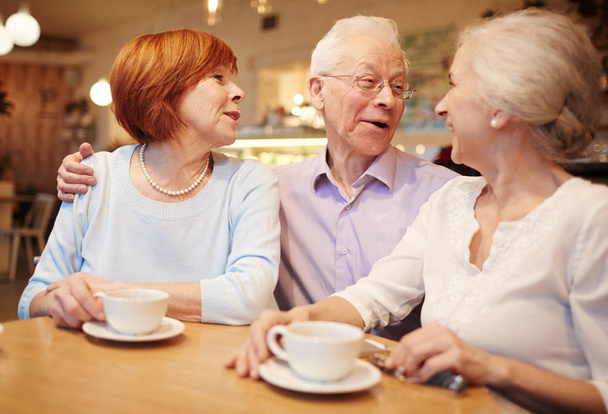 Веселые приятели наслаждаются временем и разговаривают в кафе
 - Фото, изображение