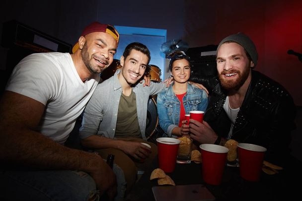 Grupa współczesnych ludzi modnych chłodzenie w nocnym klubie, picia piwa i zabawy całą noc, pozowanie spojrzeć na kamery - Zdjęcie, obraz