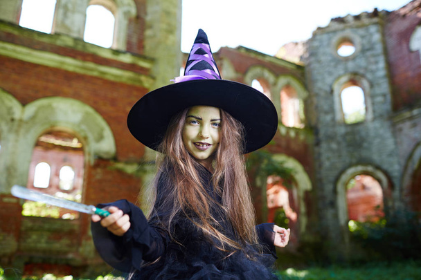 Sihirli-değnek tarafından sallayarak halloween kıyafetleri içinde şirin küçük cadı - Fotoğraf, Görsel