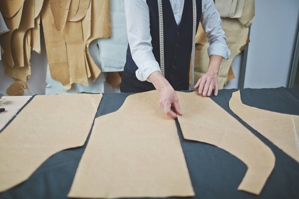 Closeup πορτρέτο του έμπειρου παλιά tailor κάνουν ρούχα στο κατάστημα atelier, για τον καθορισμό προτύπων σε ύφασμα - Φωτογραφία, εικόνα