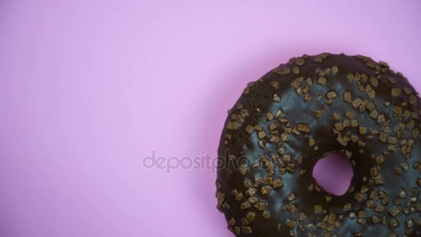 köstliche süße Donut rotierenden auf einem Teller. Ansicht von oben. hell und bunt bestreut Donut Nahaufnahme Makroaufnahme Drehen auf einem rosa Hintergrund. - Filmmaterial, Video