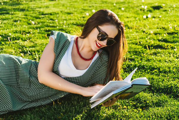 Reading woman on grass.Preparing student in park, sun glasses - Foto, Imagen