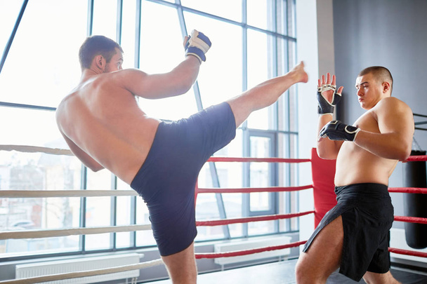 Félmeztelen birkózó küzdelem a boksz ring küzdelem gyakorlatban ellenfél portréja: kijátssza a magas rúgás fejét - Fotó, kép
