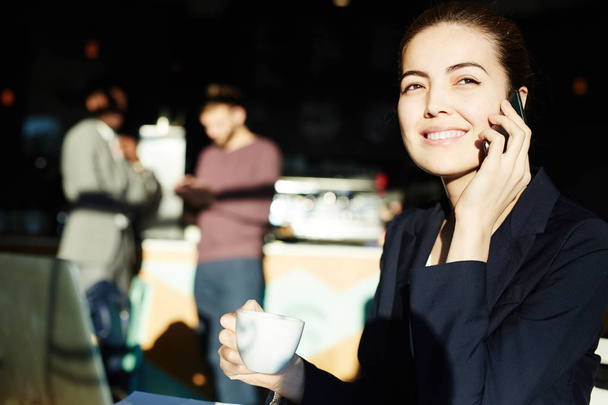 Retrato de sucesso jovem empresária bebendo café e luz solar brilhante e falando por telefone sorrindo alegremente
 - Foto, Imagem