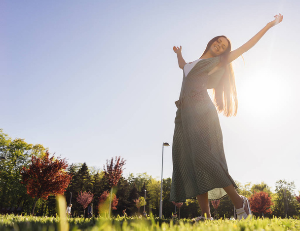 Радісна і щаслива жінка на відкритому повітрі, підняті руки, літо свободи
 - Фото, зображення