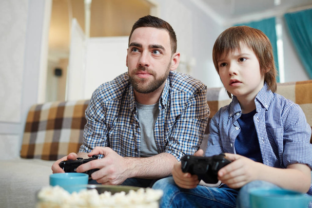 Adam ve küçük çocuk tv ekranına bakarak joystick ile - Fotoğraf, Görsel
