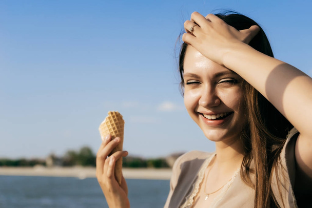 young girl in summer park smiling enjoying ice cream - Fotó, kép