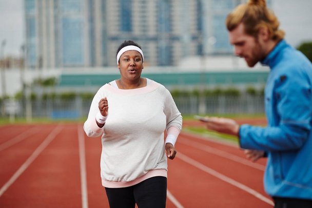 Молодая женщина с ожирением, участвующая в марафоне
 - Фото, изображение