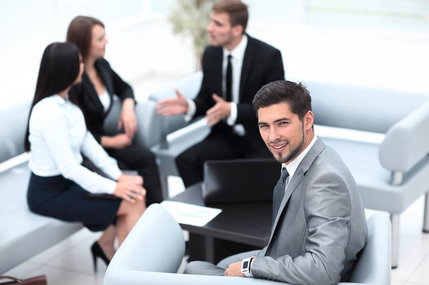 businessman sitting in an office on the background of business team. - Φωτογραφία, εικόνα
