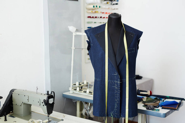 Spastische studio interieur: mannequin en werkende tabellen met naaimachines in lege werkplaats - Foto, afbeelding