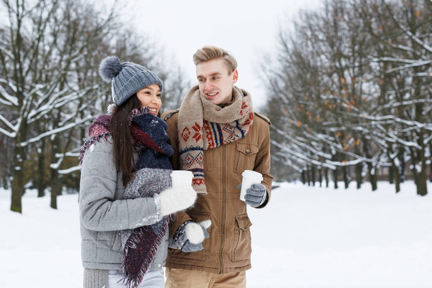 Jeunes dates avec boissons marchant dans le parc d'hiver
 - Photo, image