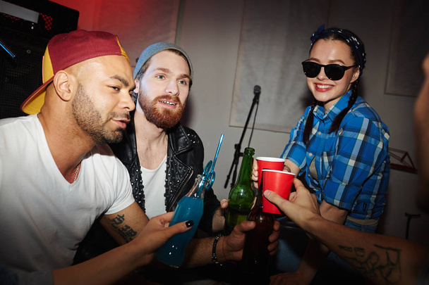 Grupa uśmiechający się młodych ludzi, mężczyzn i kobiety, picia piwa wiszące w nocnym klubie - Zdjęcie, obraz