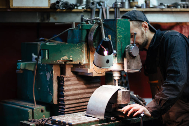 Muotokuva mies työntekijöiden yhtenäinen käyttäen poraus yksikkö tehdä metalliosat
 - Valokuva, kuva