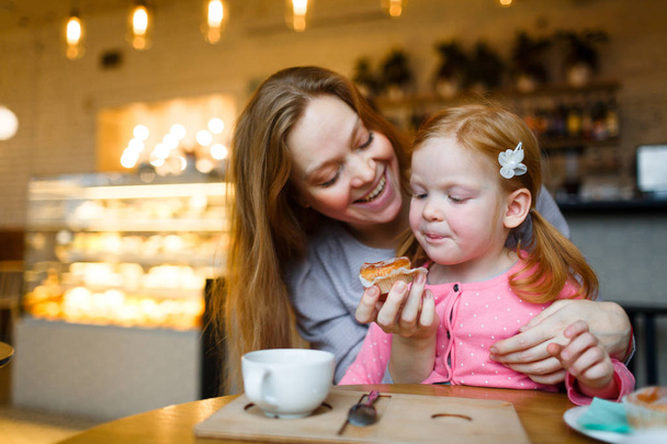 Mujer ofreciendo sabroso cupcake a su hija
 - Foto, imagen